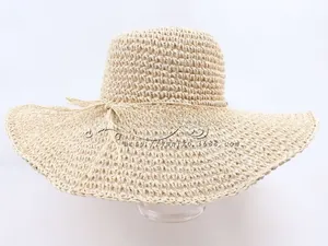 Detail of hand-woven beige straw hat with wide brim and decorative bow for sun protection
