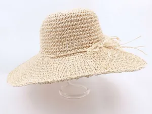 Handwoven wide brim straw sun hat in cream white with decorative side bow for beach