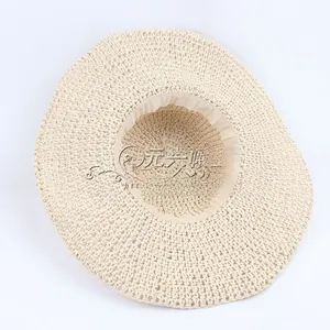 Detail of light beige handmade crochet straw hat with wide brim and foldable texture