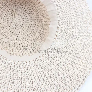 Detailed view of the tight woven texture and inner sweatband of this beige straw sun hat