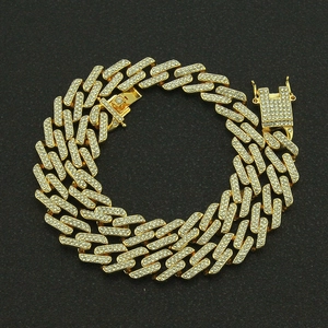 Macro shot of gold-plated Cuban chain bracelet with colorful pavé diamonds and box clasp