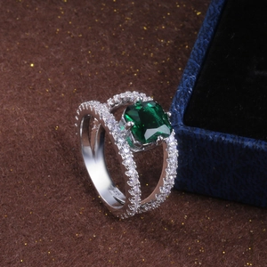 Dettaglio macro dell'anello con gemma verde taglio smeraldo e zirconi su fascia argento