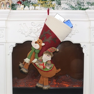 Chaussette de Noël avec Père Noël et renne sur cheminée avec décorations de fête