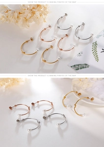 Dettaglio di orecchini a nodo minimalista con perle in oro, oro rosa e argento lucido