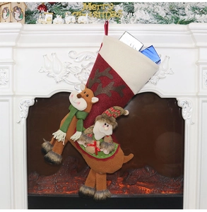 Détail de chaussettes de Noël avec Père Noël et renne suspendues à la cheminée décorée