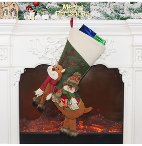 Chaussette de Noël avec renne et bonhomme de neige suspendue devant la cheminée