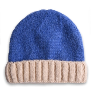 Gros plan détaillé sur le tricot côtelé bicolore bleu et beige du bonnet d'hiver