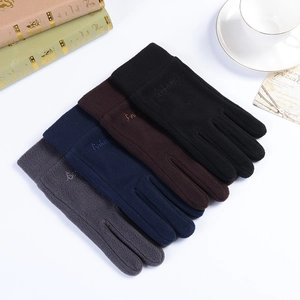 Gants d'hiver en polaire en noir, marron, bleu marine et gris empilés sur une table