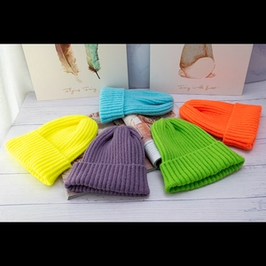 Colorful winter knit beanies in yellow, purple, green, orange and light blue colors