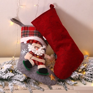 Plaid Christmas stockings with Santa figurines on a decorated festive mantelpiece