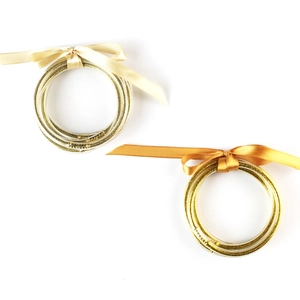 Bracciali tubolari flessibili glitterati con fiocchi decorativi in seta color oro e champagne