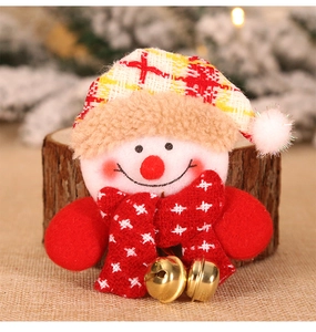 Macro shot of a Christmas snowman pin featuring red plaid hat and golden jingling bells