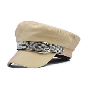 Detailed view of khaki military cap with rhinestone strap and silver metal buckle