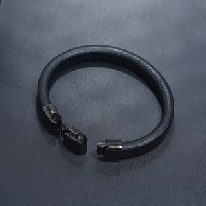 Detail of minimalist black leather bracelet with an open sleek black metal buckle closure