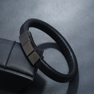 Close-up of black leather bracelet with magnetic clasp on a textured gift box