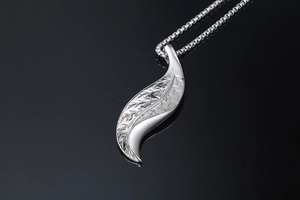 Macro detail of silver leaf pendant showing intricate texture and round box chain