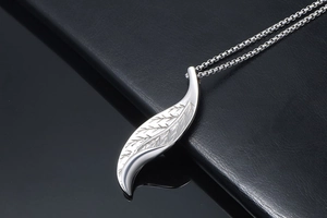 Macro shot of silver leaf pendant with detailed vein texture on a sleek box chain