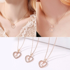 Vintage gold heart necklace with 26 letters and rhinestones shown on model and flat lay