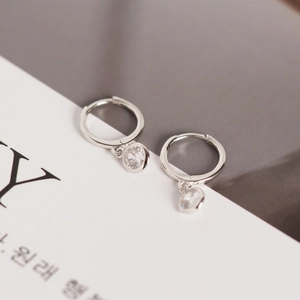 Detailed macro view of S925 sterling silver hoop earring with sparkling zircon pendant