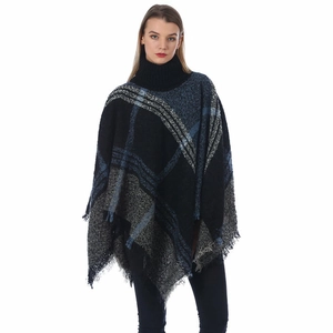 Close-up of high turtleneck knit poncho featuring blue plaid pattern and fringe tassels
