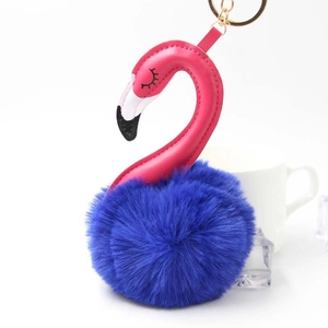 Detail of pink leather flamingo keychain with deep blue pom-pom body and gold ring