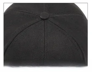Dettaglio delle cuciture a sei pannelli e del bottone superiore di un cappello nero in cotone