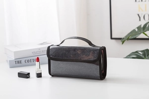 Detail of black glitter makeup bag with a sturdy top handle and waterproof PVC material