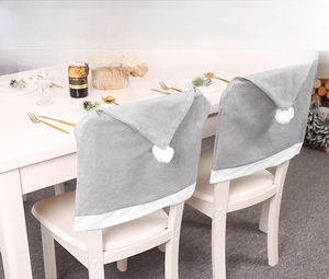 Detailed view of grey plush Christmas hat chair covers in a festive dining setting