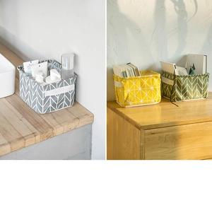 Detail showing foldable linen desktop storage baskets with handles and geometric patterns