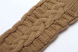 Close-up of camel knit gloves featuring a classic cable stitch pattern and soft wool texture