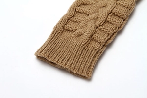 Macro detail of camel knitted fingerless gloves featuring chunky rib cuffs and soft wool texture