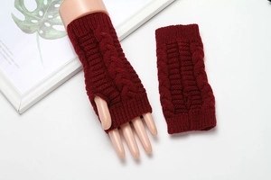 Close-up of wine red cable-knit fingerless gloves showing yarn texture and warm design