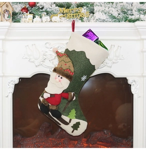 Detail eines waldgrünen Nikolausstiefels mit skifahrendem Weihnachtsmann am Kamin