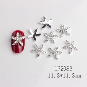 Detailed view of silver starfish nail charms with rhinestones and size comparison