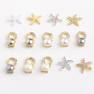 Macro detail of starfish pendants and pearl charms with rhinestones for DIY nail art