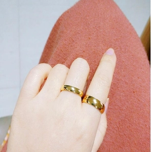 Detail shot of a person wearing two minimalist gold-colored titanium steel rings