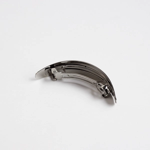 Close-up of minimalist gunmetal spring hair clip with smooth curved metallic surface