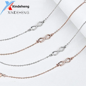 Close-up of 925 silver and rose gold infinity pendants with sparkling micro-inlay stones