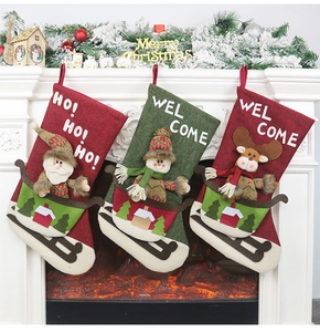 Three festive Christmas stockings with felt Santa and Reindeer hanging on a fireplace