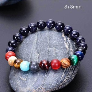 Detail of solar system planet bracelet with 8mm natural stones on a grey rock background