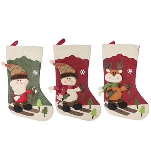 Drei Weihnachtssocken mit Nikolaus-, Schneemann- und Rentier-Motiven beim Skifahren