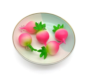 Close-up of five gradient radish vegetable charms in a gold-rimmed ceramic dish