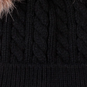 Detailed macro view of black cable knit pattern and texture on a winter baby hat