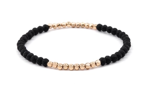 Detail of Miyuki stretch bracelet featuring faceted black beads and gold-tone spacers