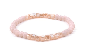 Detail of pink crystal faceted beads and gold-tone tube on minimalist elastic bracelet