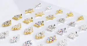 Detailed view of turtle-shaped nail art charms with pearls and sparkling rhinestones