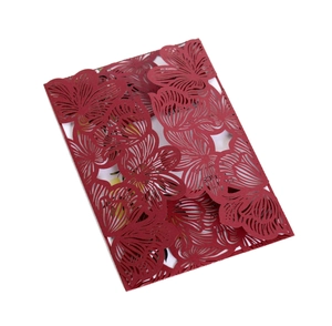 Detail of red laser-cut floral wedding invitation cover with intricate hollowed patterns