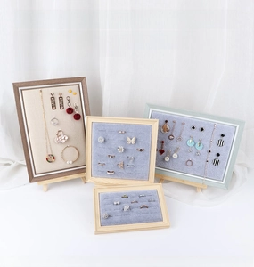 Detailed view of wooden jewelry display frames with velvet slots for earrings and rings