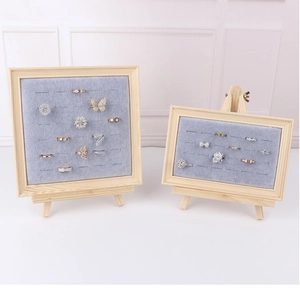 Detail of wooden jewelry display stands with grey velvet slots for rings in two sizes