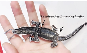 Detail of movable silver crocodile brooch showing flexible joints and large size on hand